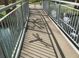 PITTVILLE PEDESTRIAN COMMUNITY BRIDGE - 2012 - Pittville Park, Cheltenham - Span 21.5M (70’). Client: Cheltenham Borough Council. SHADOWS ON FOOTWAY
. Designed  & made by Christopher Lisney (with community groups input, & large scale fabrication, Longhope Welding). Copyright Chistopher Lisney 2014 - All Rights reserved by DESIGN PROTECT